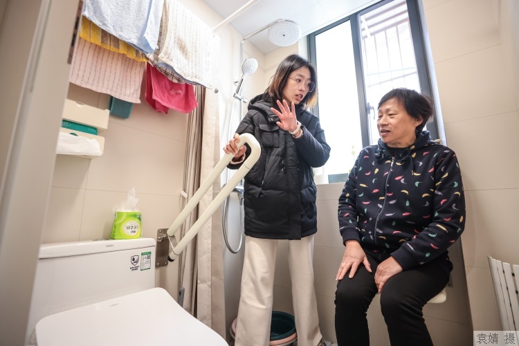 适老化改造评估师正在为老人讲解扶手的用法。资料图